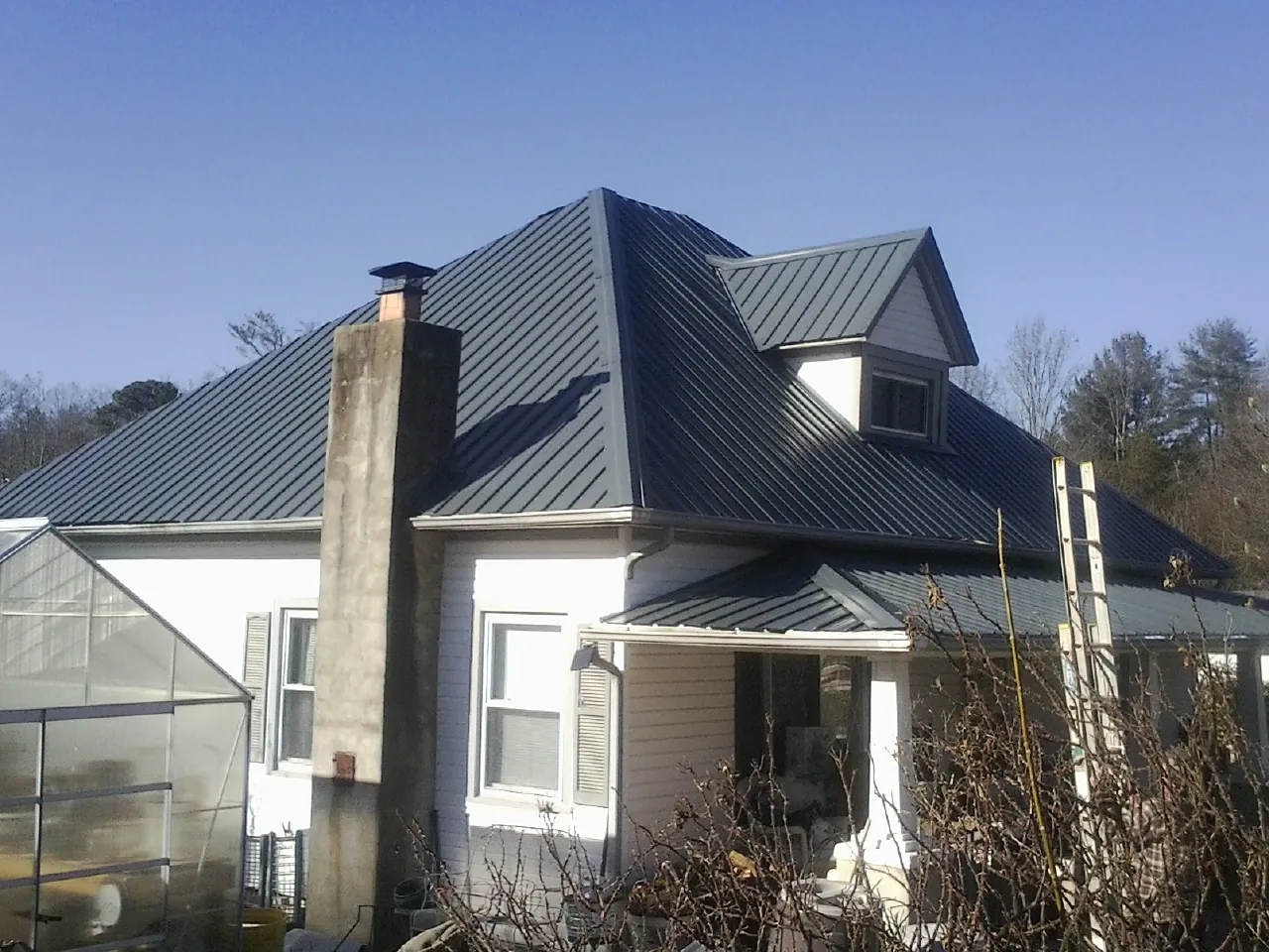 Dark blue standing seam metal roof on a white farmhouse with dormer — Slate & Tile Roof Repair by Roofing Brothers in Santa Ysabel
