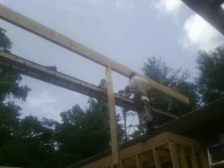 Carpenter setting a ridge beam over a new addition frame — Ice Dam Removal by Roofing Brothers in Santa Ysabel