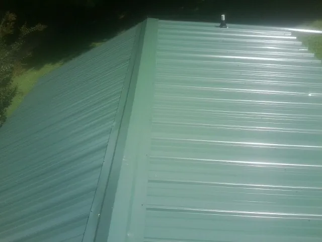 New green metal panels meeting at the ridge of a roof — Flat Roof Repair work by our crew in Santa Ysabel