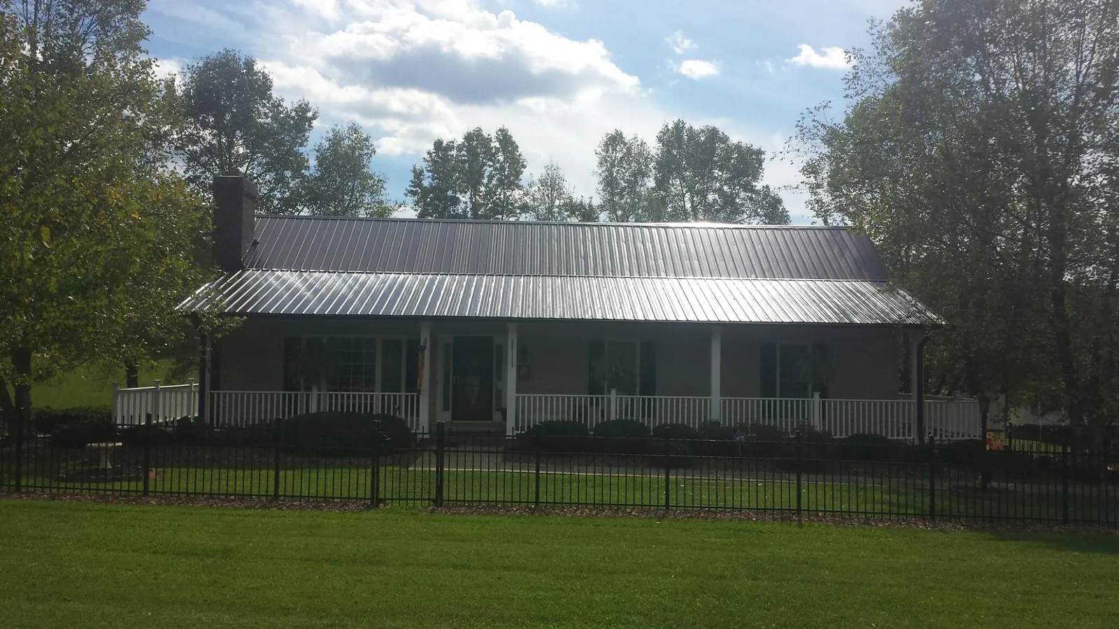 Gray metal roof on a brick ranch with a full width front porch — Gutter Guard Installation work by our crew in Santa Ysabel